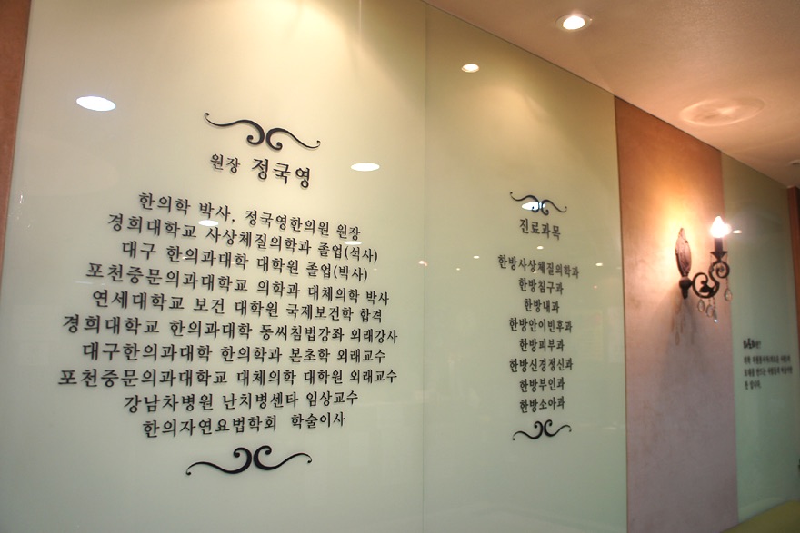 정국영한의원 내부에 새겨진 정국영 원장 약력과 진료과목 안내 벽면